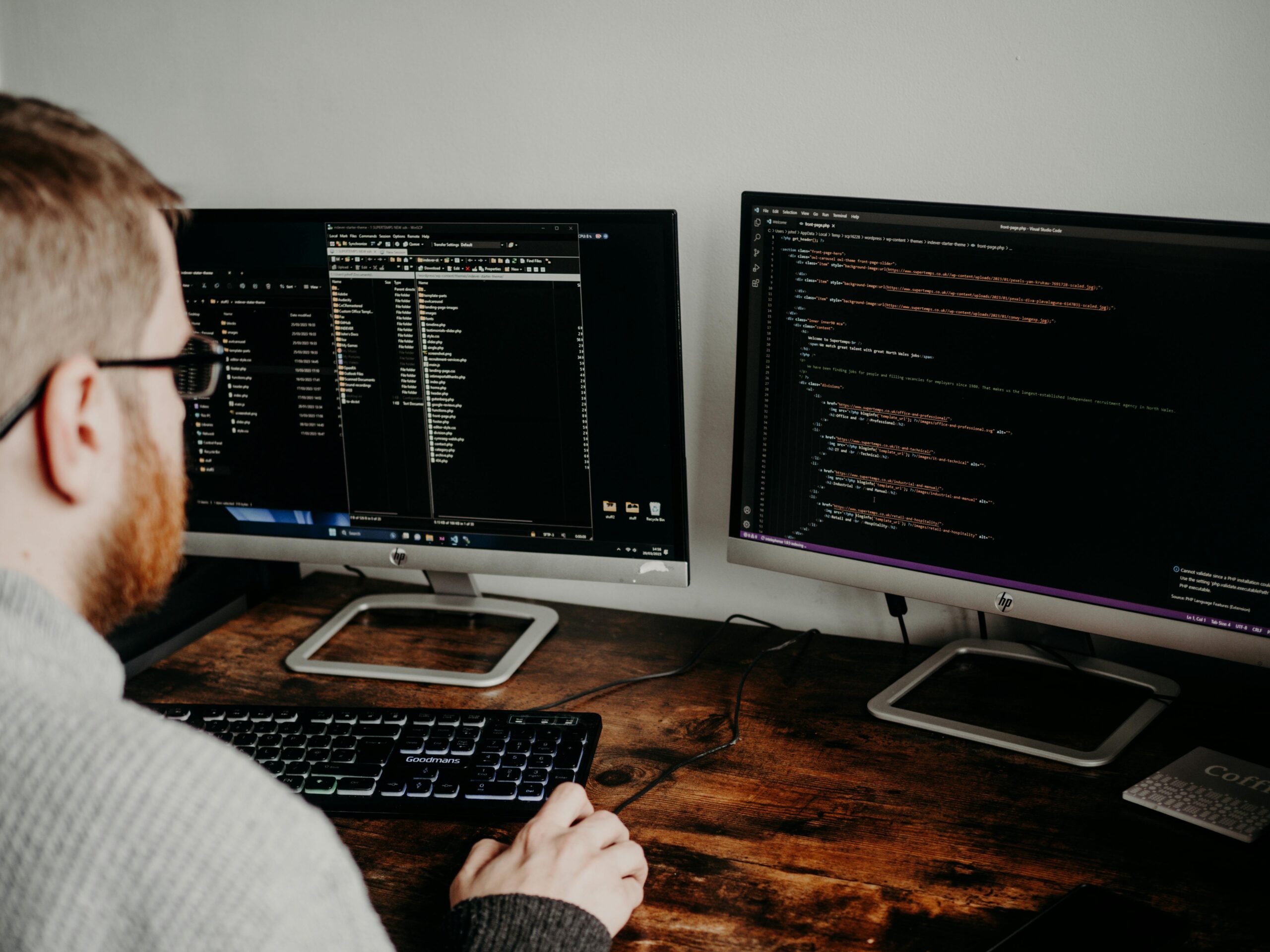 Developer working with code on dual monitors